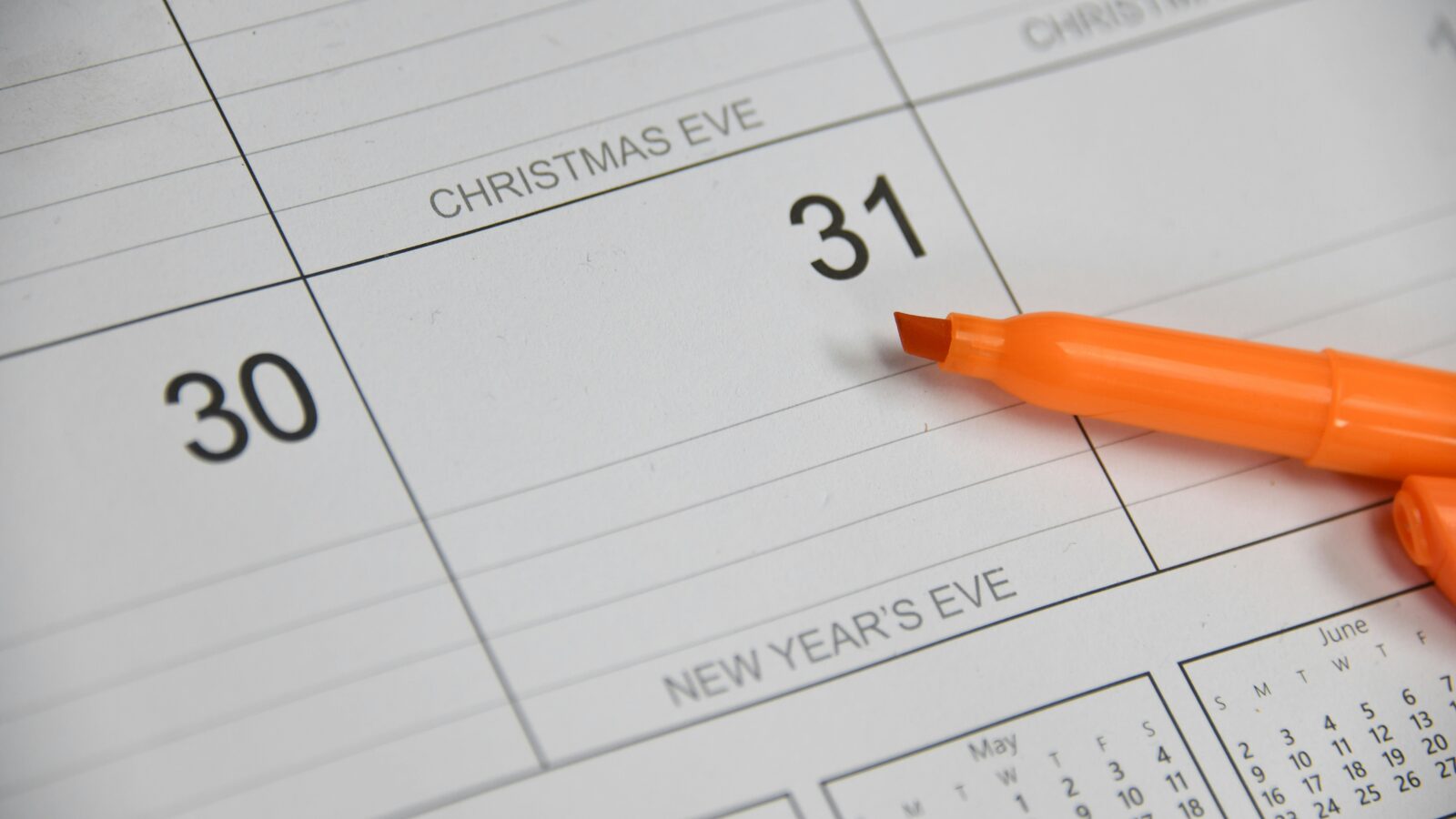 A felt-tip marker lying on a printed month-view wall calendar