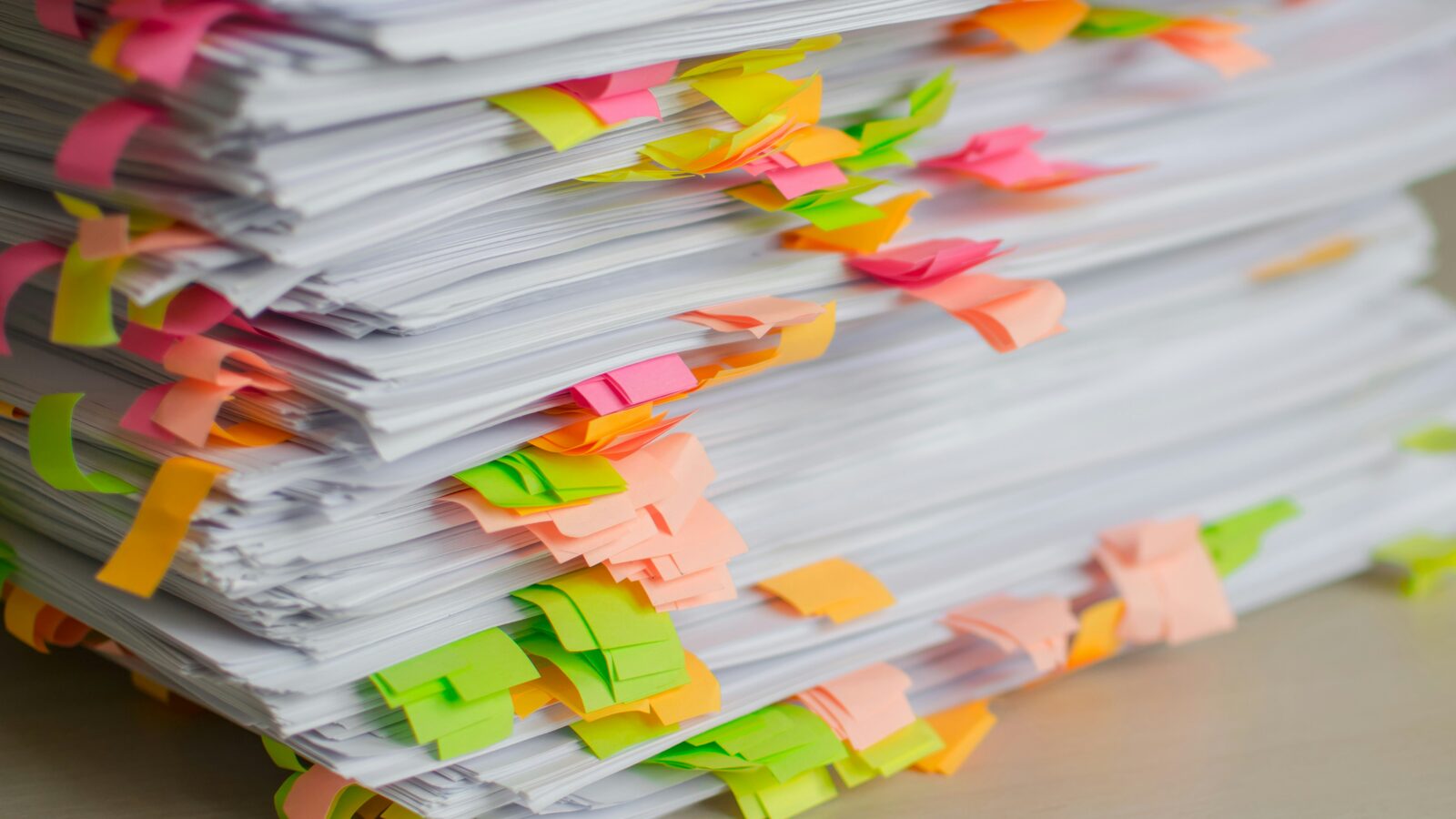 A stack of papers marked with coloured sticky tabs