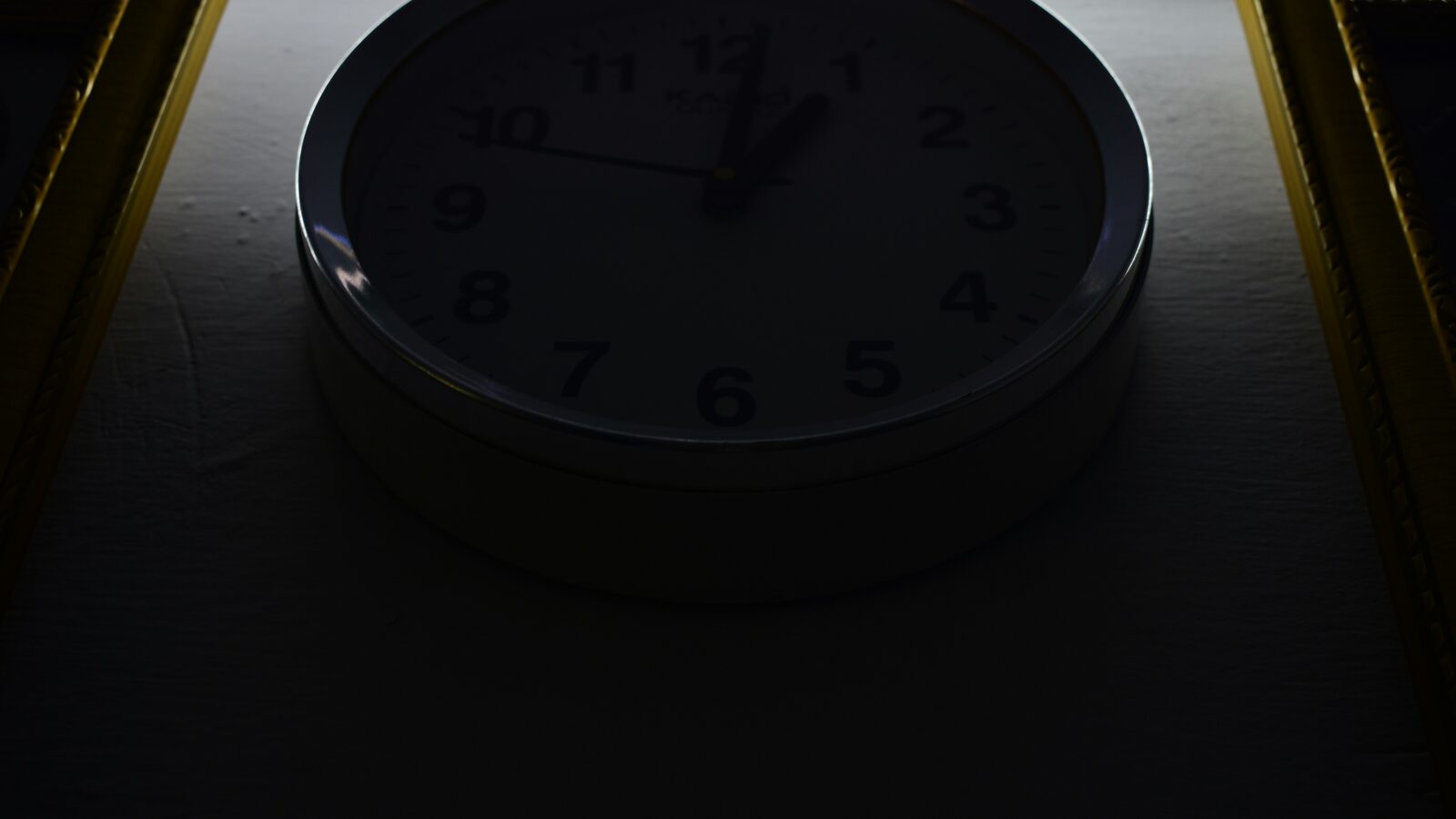 A clock face with the hands pointing to nearly twelve
